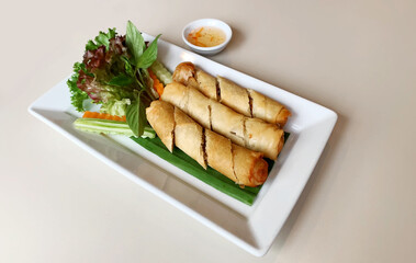 Spring Roll or Egg Roll Popular Thai snacks on a white plate on a grey wooden table.