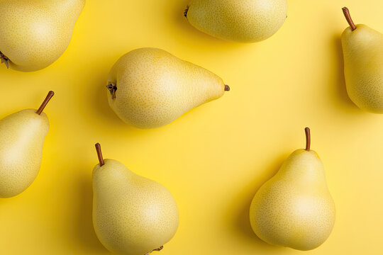Ripe yellow pears arranged on vibrant yellow background