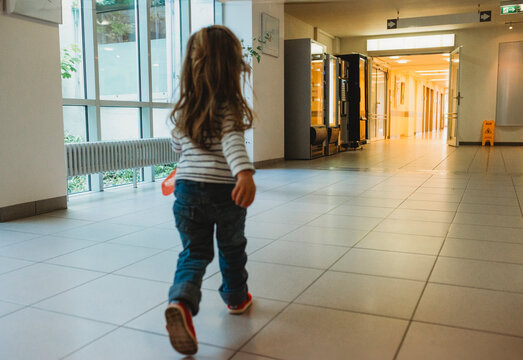 Young child walking through hospital aisle
