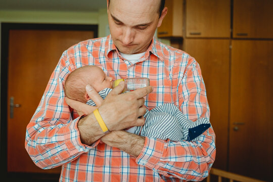 Father feeding newborn baby milk bottle at hospital fresh 48