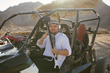 Man tourist with arafatka on quad bike ATV safari