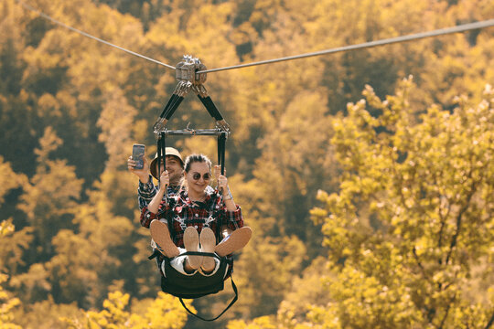 Couple Enjoying Zipline Adventure in Forest