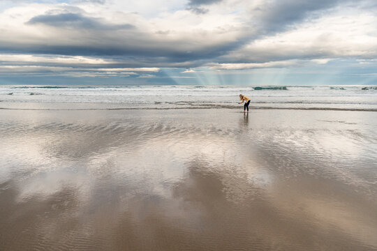 Person beach combing on beautiful beach at dusk