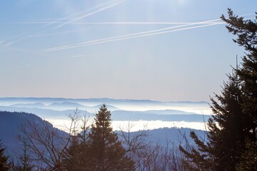 Winterliches Panorama an der Hornisgrinde im Schwarzwald mit Wolken im Tal und einzelnen aus dem Nebel herausragenden Berggipfeln