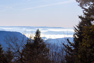 Winterliches Panorama an der Hornisgrinde im Schwarzwald mit Wolken im Tal und einzelnen aus dem Nebel herausragenden Berggipfeln