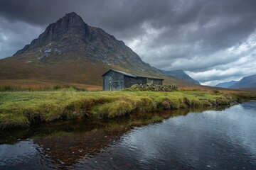 A Mountain hut, Glencoe, highlands, Scotland with dramatic mountain backdrop.