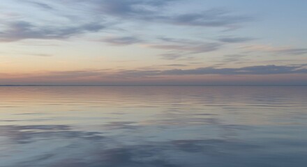 Obraz premium Serene sunset over calm water reflections.