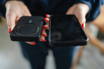 unknown woman hands holding phone and power bank charge