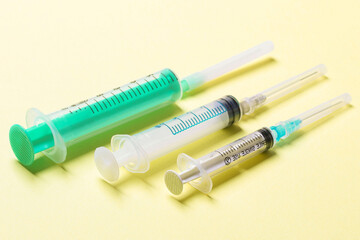 Fototapeta premium Top view of different syringes for injection on colorful background. Medical equipment concept with copy space