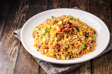 Japanese style eel fried rice including cucumber and egg served on plate isolated on napkin side view of hong kong food on wooden background