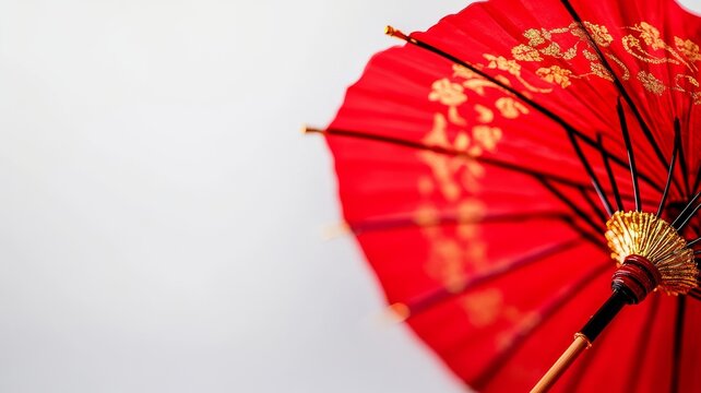A vibrant red umbrella with intricate gold patterns, symbolizing elegance and cultural significance in traditional art.