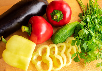 Fresh vegetables and herbs arranged on a wooden cutting board
