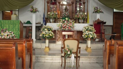 Traditional Latin American Catholic church with large wooden altar and floral arrangements. Honduras