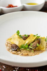 Mushroom ravioli in white porcelain plate on wooden table
