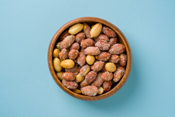 Top view of salted peanuts in wooden bowl