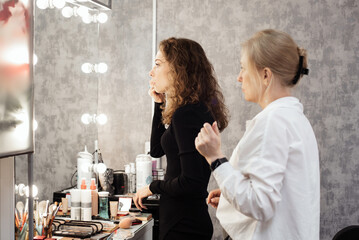 A professional makeup artist conducts a master class on professional development, observing the student's work.