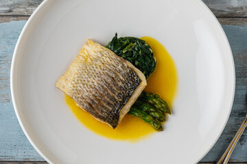 Grilled sea bass fillet served with garnishes in a fine dining restaurant