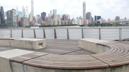 New York City waterfront skyline, Manhattan Midtown buildings, riverfront skyscrapers by East river water. Waterside cityscape, Gantry Plaza Park, Long Island, Queens, United States. Riverside bench.