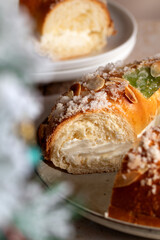 Spanish Three kings cake on decorated table with Christmas tree and burning candles, celebration of Three Kings Day