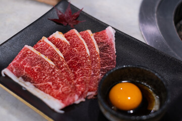 Premium wagyu beef meat served with egg yolk in sukiyaki yakiniku Japanese restaurant