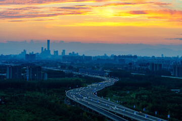 Obraz premium Road towards the sun: skyline of Beijing CBD area at sunset