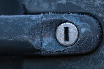 Frozen car lock, hard frost. Gray background. Winter time.