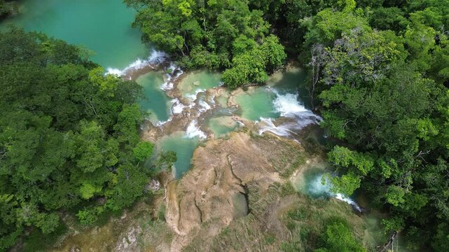 Stunning aerial overview establishing of Roberto Barrios waterfalls flowing through dense tropical jungle