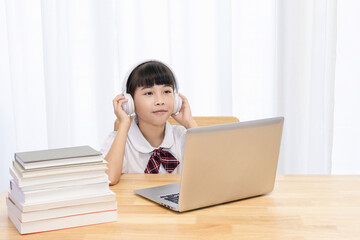 Chinese little girl attending online classes at home