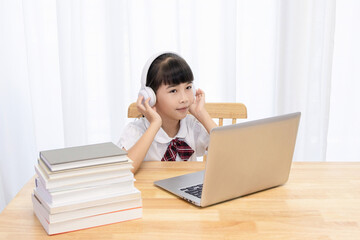 Chinese little girl attending online classes at home
