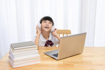Chinese little girl attending online classes at home