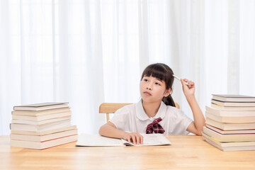 The little Chinese girl is doing homework at home