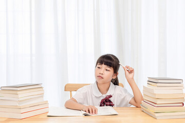The little Chinese girl is doing homework at home