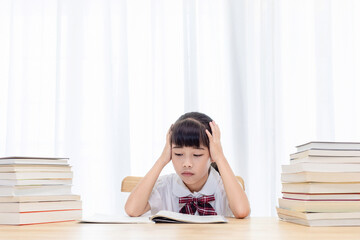 The little Chinese girl is doing homework at home