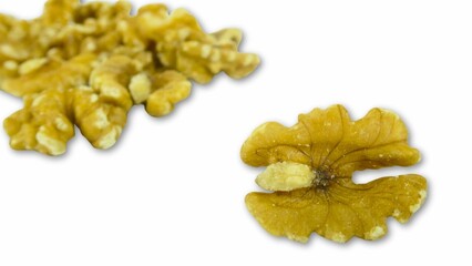 A detailed macro photograph of a handful of walnut halves isolated on a white background, emphasizing their intricate texture, rich golden-brown color, and natural beauty. Perfect for healthy eating, 