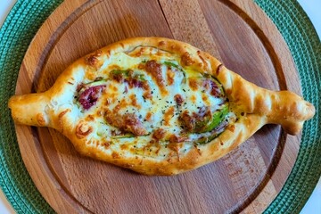 Georgian food. Khachapuri on a wooden plate.