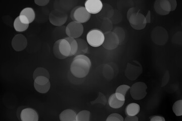 Silver, black and white bokeh background with soft, circular light spots in varying sizes. The dreamy, out-of-focus effect creates an abstract, atmospheric, and versatile backdrop