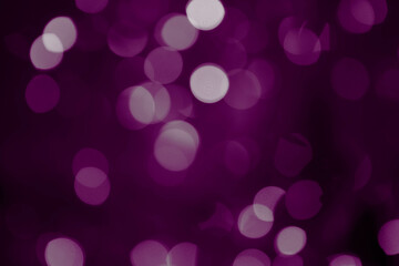 Purple, magenta, indigo bokeh background with soft, circular light spots in varying sizes. The...