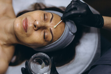 Middle aged woman getting anti aging facial peeling treatment at a cosmetic clinic