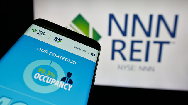 Stuttgart, Germany - 12-09-2024: Smartphone with website of US real estate company NNN REIT Inc. on screen in front of business logo. Focus on top-left of phone display.
