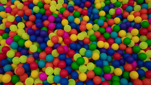 Brightly colored plastic balls in multiple hues fill a lively play area, creating a fun environment for children to enjoy during a sunny outing.