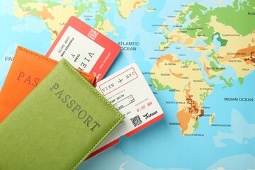 Passports with tickets on world map, top view