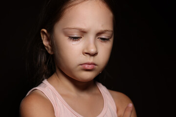 Fototapeta premium Orphanage concept. Sad girl on black background