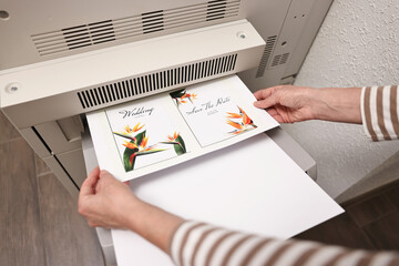 Woman using modern printer indoors, closeup. Printing house