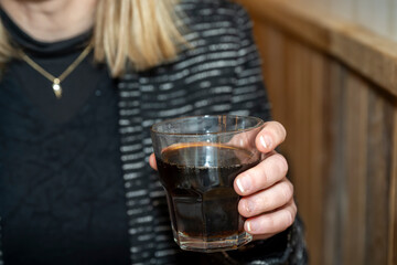 verre de soda dans la main d'une femme dans un caf&eacute;