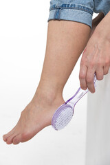 A girl cleans old leather from her feet 