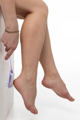 A girl cleans old leather from her feet 