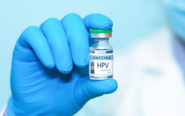 A doctor holds a vial of the HPV vaccine. Experimental HIV vaccine vial for immunization against HPV disease.