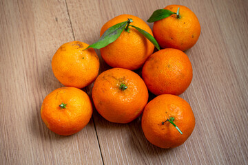 Fresh tangerines with vibrant orange hues on a rustic wooden table, evoking a sense of natural simplicity and healthy living. Perfect for seasonal or food-related themes.
