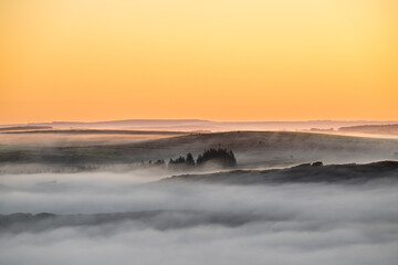 A winter sunrise landscape vignette during a temperature inversion at The Roaches in the Peak District National Park, England, UK.