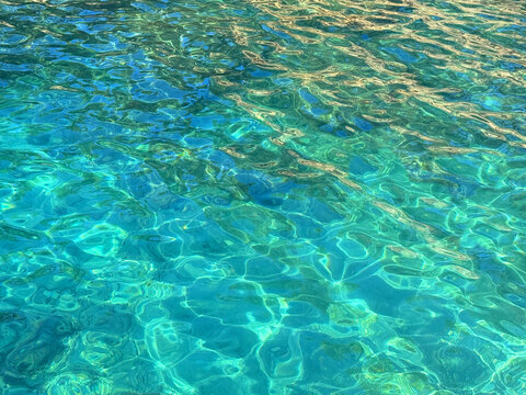 Emerald green blue ocean water clear glittering surface.